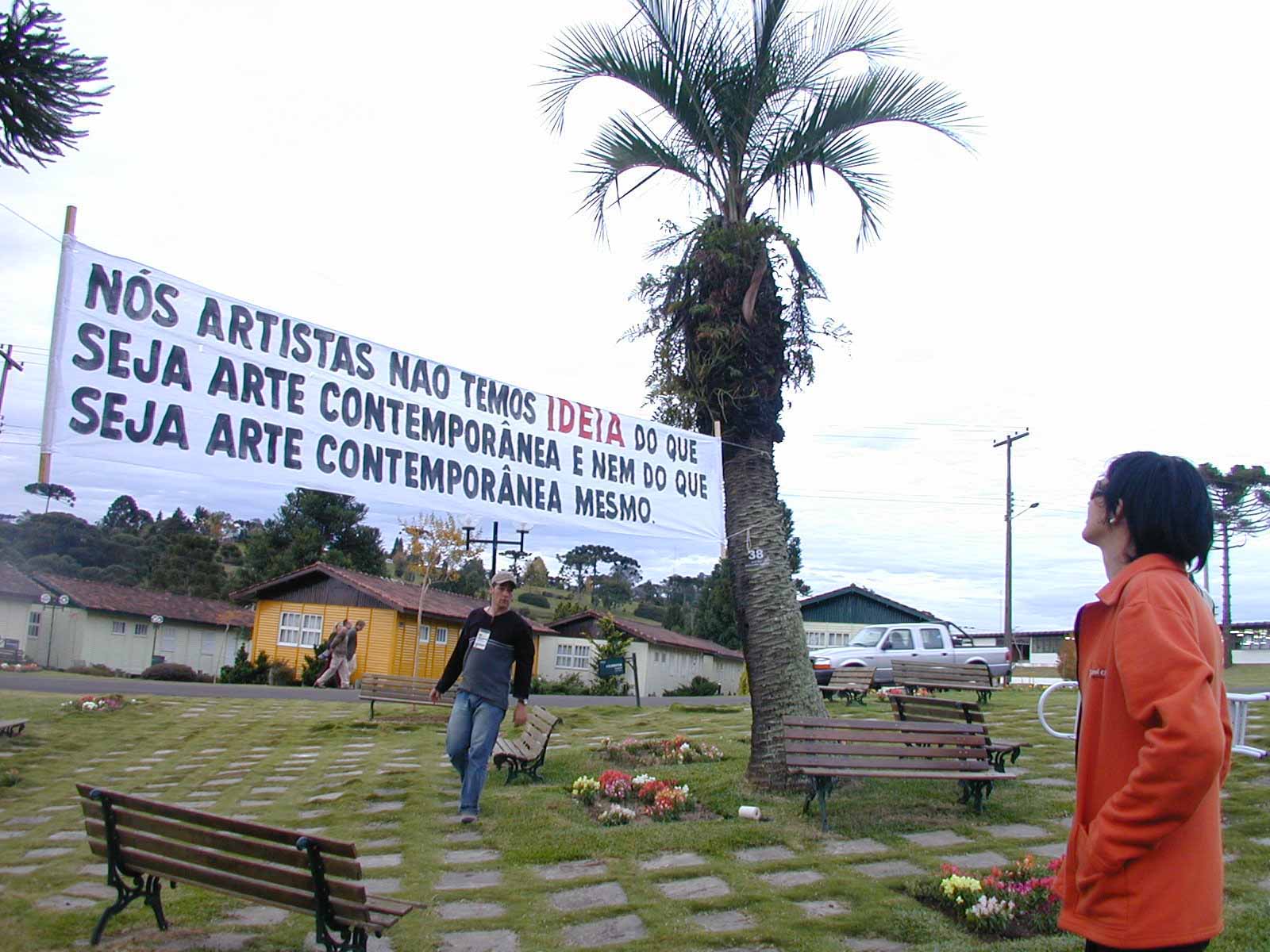 Intervenção de Marta Neves em Faxinal das Artes; na faixa se lê "Nós artistas não temos IDEIA do que seja arte contemporânea nem do que seja arte contemporânea mesmo"