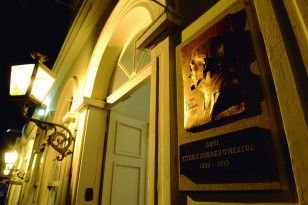Fachada do Museu Casa Alfredo Andersen. Foto noturna com luz da rua. Portas abertas.