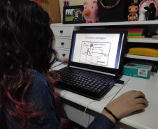 A estudante do curso de Fotografia do CJAP, Laura Pacheco, estuda o conteúdo enviado em seu computador. Foto Priscila Pacheco.