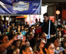 Homem vestido de Drácula entregando pipoca para as pessoas