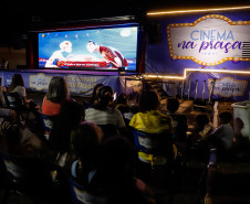 Pessoas assistindo cinema em uma praça com o caminhão do projeto na frente