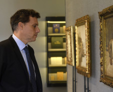 Luiz Vidal observa as obras de Alfredo Andersen. 