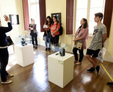 Passeio guiado pela exposição "Revisitando Curitiba" começa na sede do MIS-PR com explicações sobre as fotografias. 