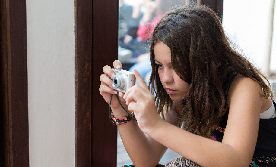 Aluna do curso de fotografia cobrindo a abertura de uma exposição no Centro Juvenil de Artes. Foto Maringas Maciel