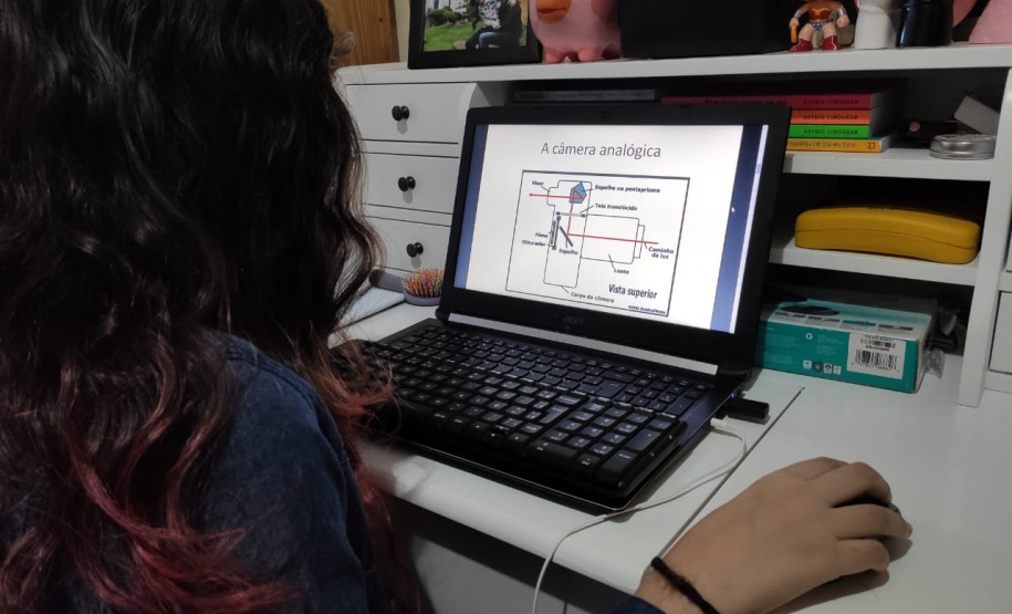 A estudante do curso de Fotografia do CJAP, Laura Pacheco, estuda o conteúdo enviado em seu computador. Foto Priscila Pacheco.