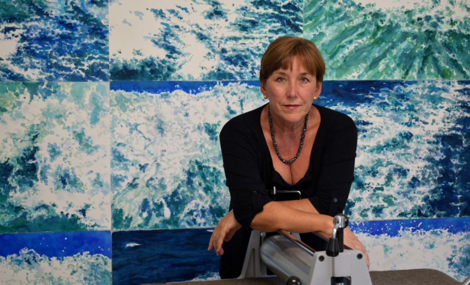 A artista Dulce Osinski diante de uma de suas obras da exposição Verdeazul