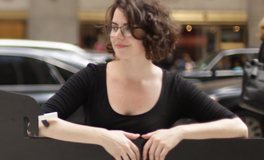 Foto de Isabel Sanchez debruçada sobre um balcão com carros ao fundo