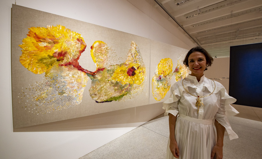 Mulher lê com criança no colo na FLIB