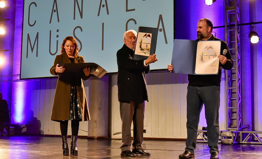 Luciana Casagrande, Darci Piana e João Evaristo DeBiase recebem placas com o brasão do estado feito por Alfredo Andersen