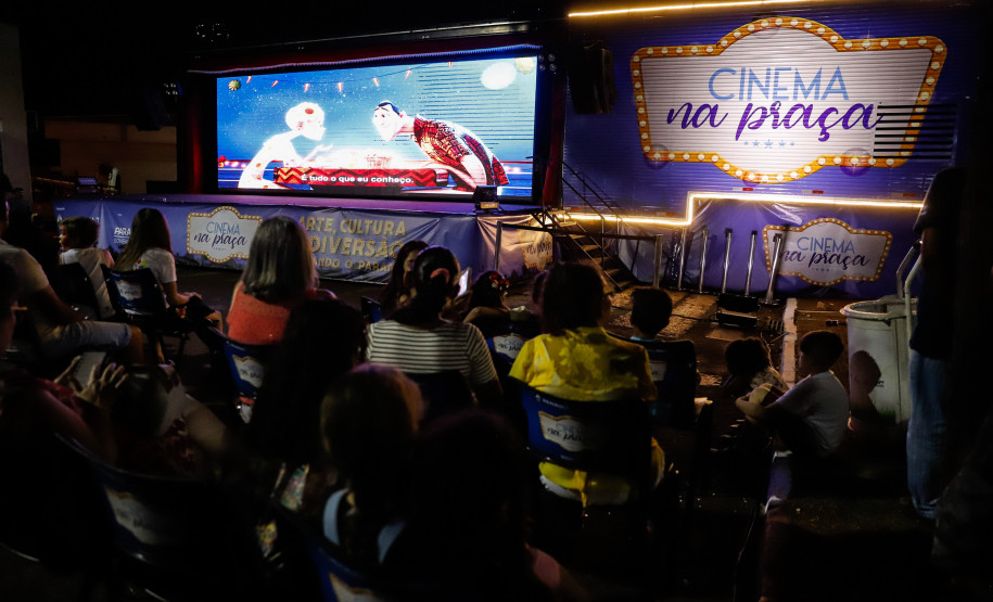 Pessoas assistindo cinema em uma praça com o caminhão do projeto na frente