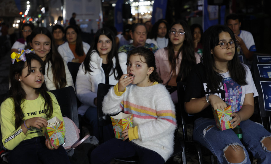 Crianças sentadas comento pipoca