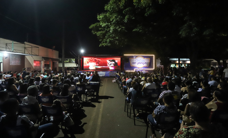 Pessoas assistindo cinema em uma praça