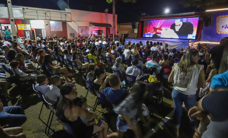 Pessoas assistindo cinema em uma praça