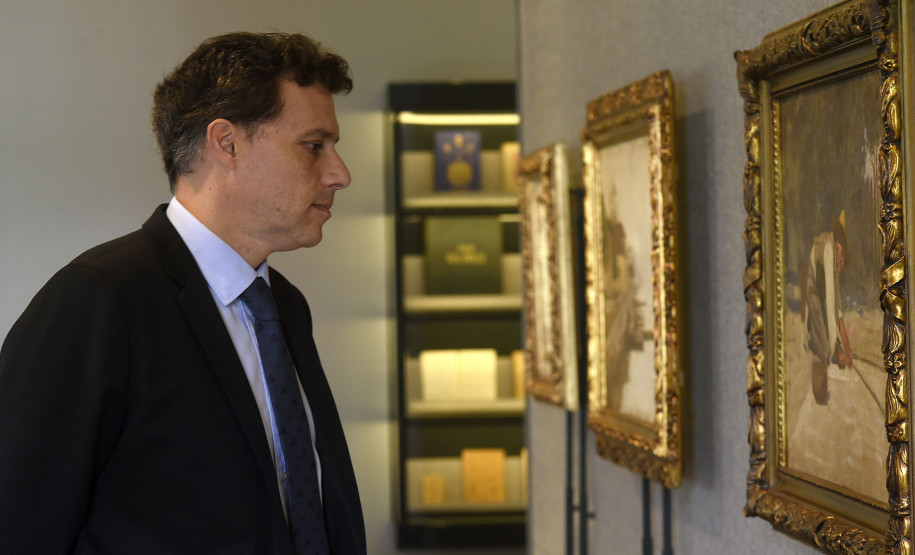 Luiz Vidal observa as obras de Alfredo Andersen.