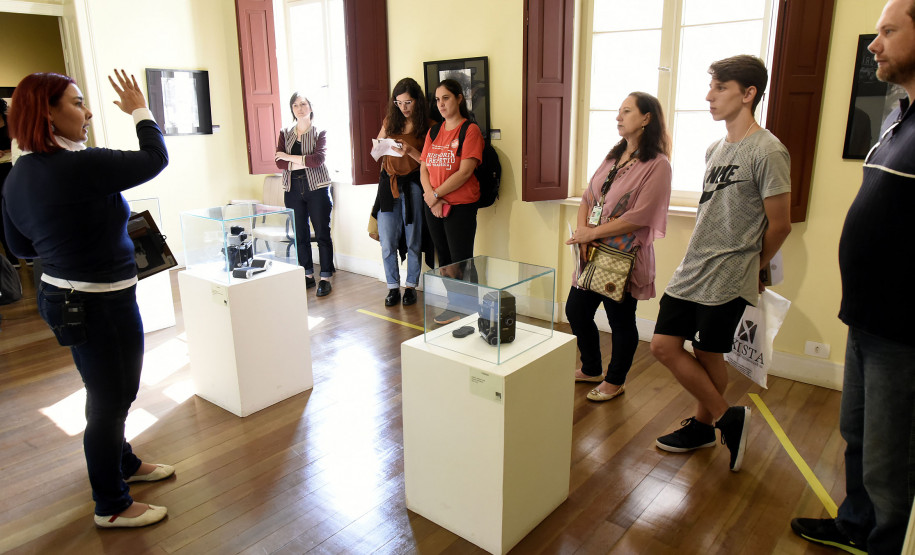 Passeio guiado pela exposição "Revisitando Curitiba" começa na sede do MIS-PR com explicações sobre as fotografias.